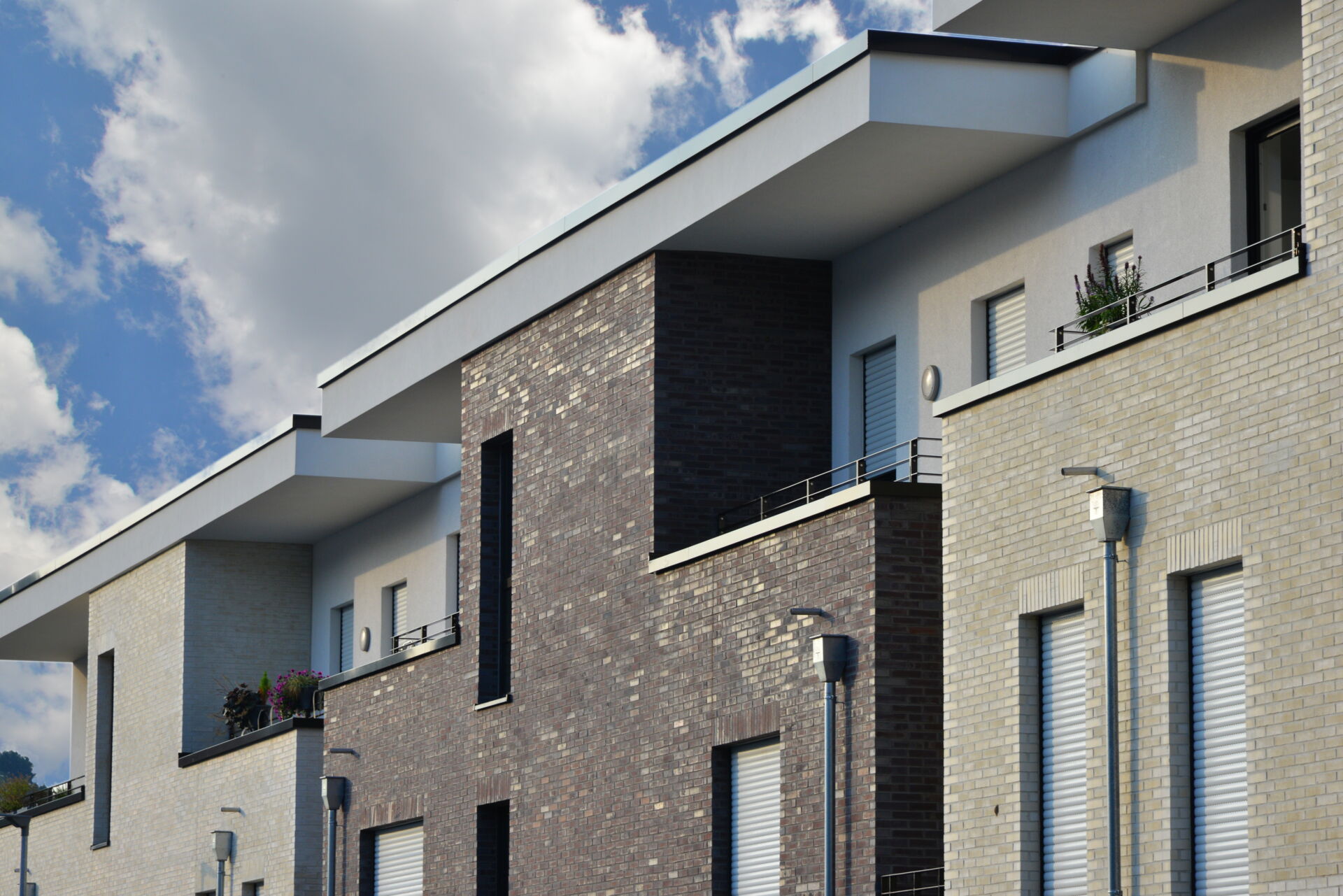Moderne Reihenhäuser mit unterschiedlichen Fassadenfarben und klaren Linien, gebaut von Weier Bau.
