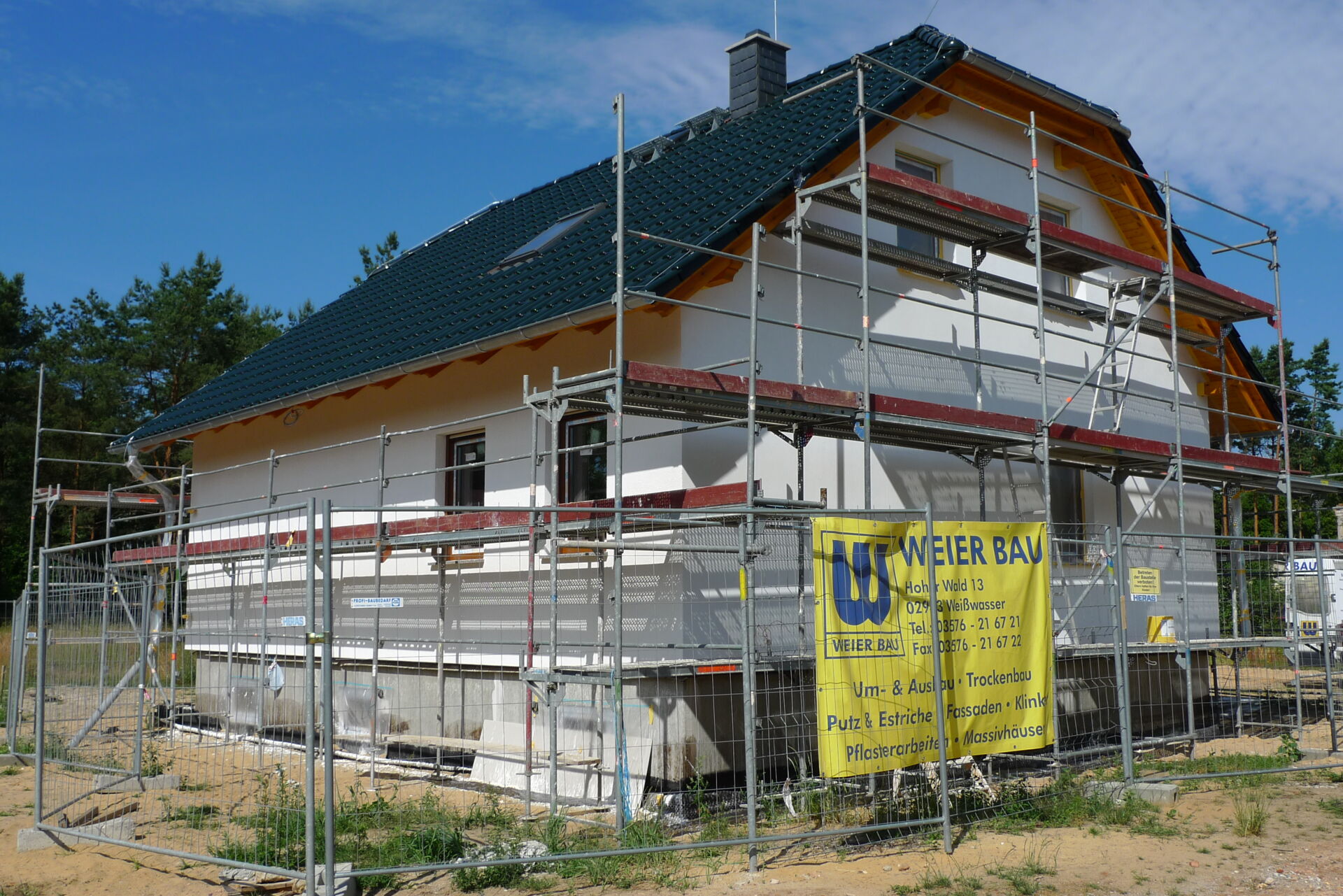 Neubau mit Gerüst und Weier Bau Bauschild; Ihr Partner für Hausbau.